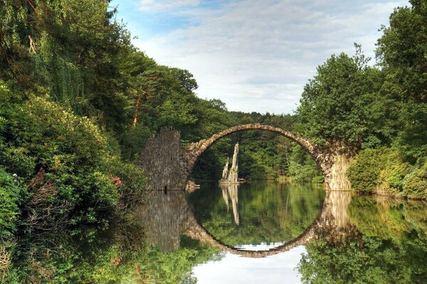 Runde Brücke mit Reflexion inmitten der Natur