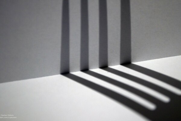 The shadow of the fork on a gray background