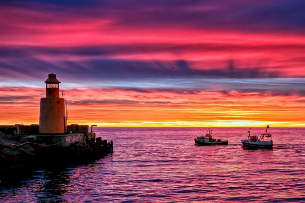 Brillante puesta de sol en el mar con un faro