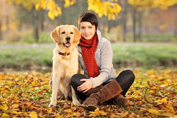 Chica con perro en el parque de otoño