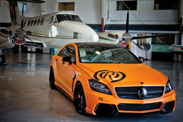 Carro esportivo laranja no fundo do avião