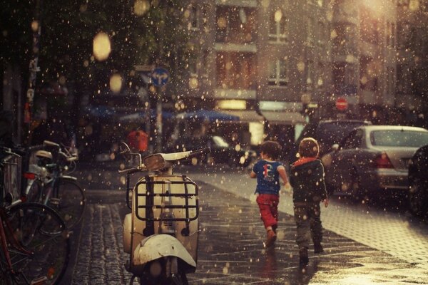 Niños corriendo para refugiarse de la lluvia que comienza