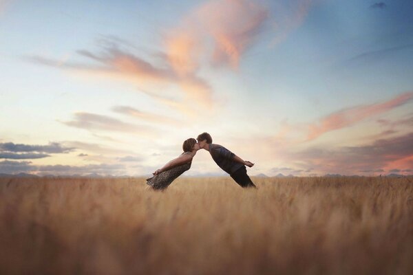 Couple kissing on the background of the field