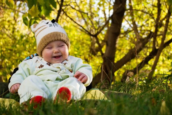 A happy child in the park is sitting on a litter