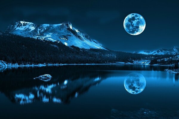 A big moon over a mountain lake in the night sky