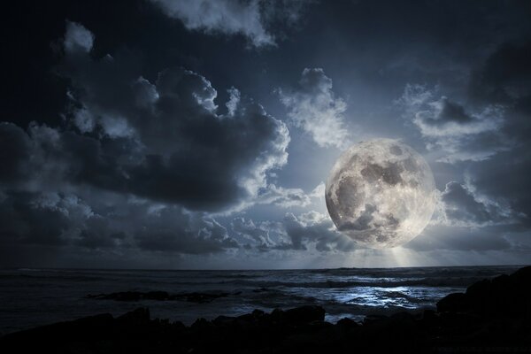 A huge moon hangs over the dark sea