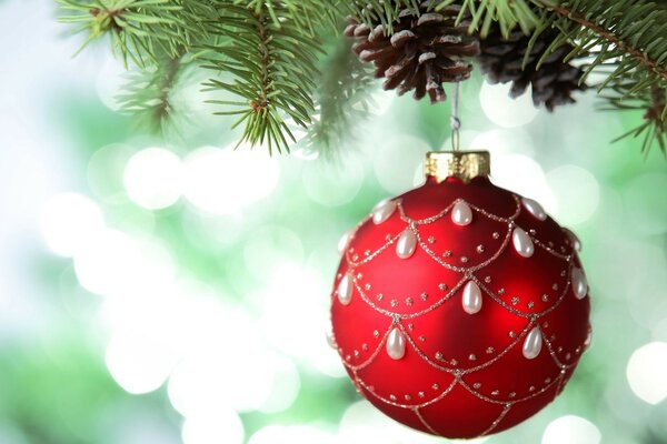 क्रिसमस ट्री सजावट। नया साल। मोती की सफेद बूंदों के साथ एक लाल गेंद । अति सुंदर क्रिसमस गेंदों