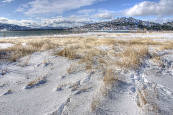 In the winter field and mountains, snow sparkles in the sun