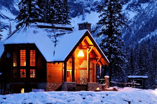 A house in the snowy mountains of the winter forest