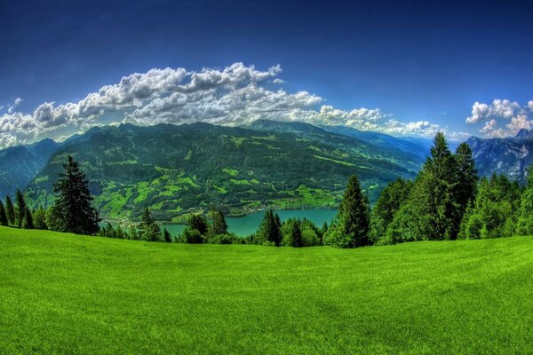 Malerisches Tal mit See und weißen Wolken