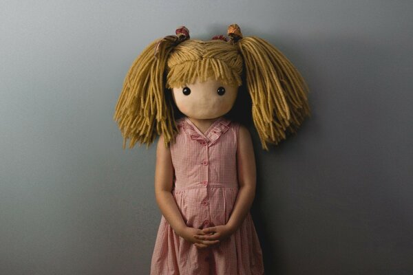 Retrato de una niña con una cabeza de muñeca