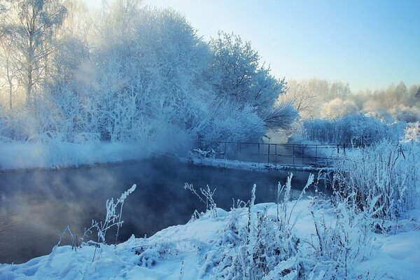 Brücke über dem Fluss. Winter verschneite Landschaft