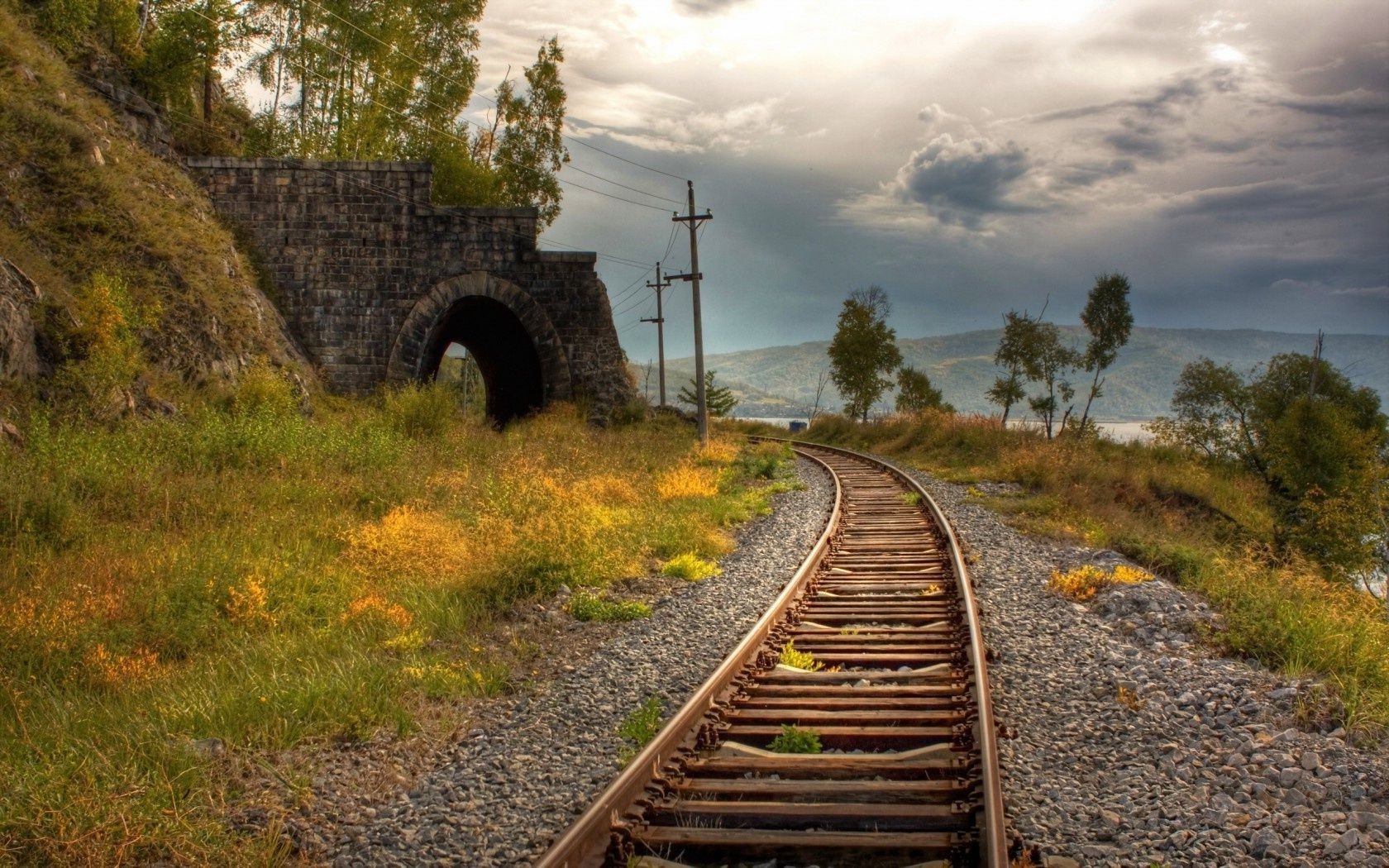 road track railway guidance train travel landscape outdoors grass sky nature tree transportation system daylight