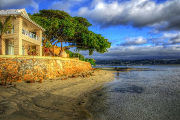 Coucher du soleil. Maison sur la plage