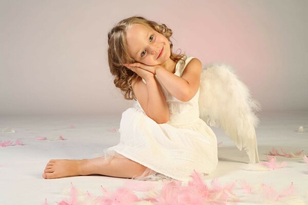 The child is an angel. A little girl in an angel costume. White wings, white dress