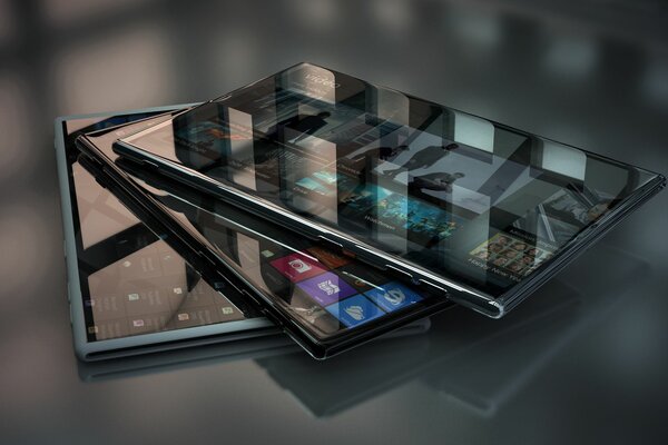 Trzy nowe smartfony leżące na szklanej powierzchni