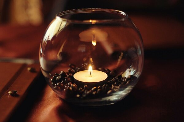 Candle in a glass on the table, still life