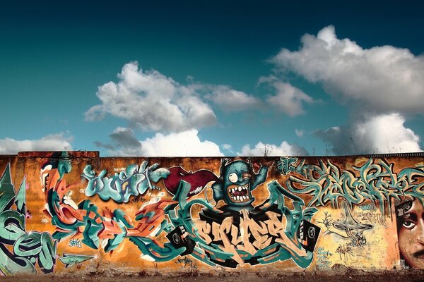 Il muro è scritto di grafite sotto il cielo blu