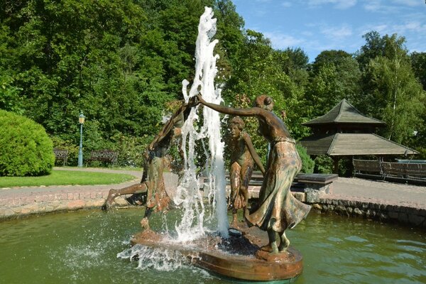 Escultura de niñas en un coro alrededor de la fuente