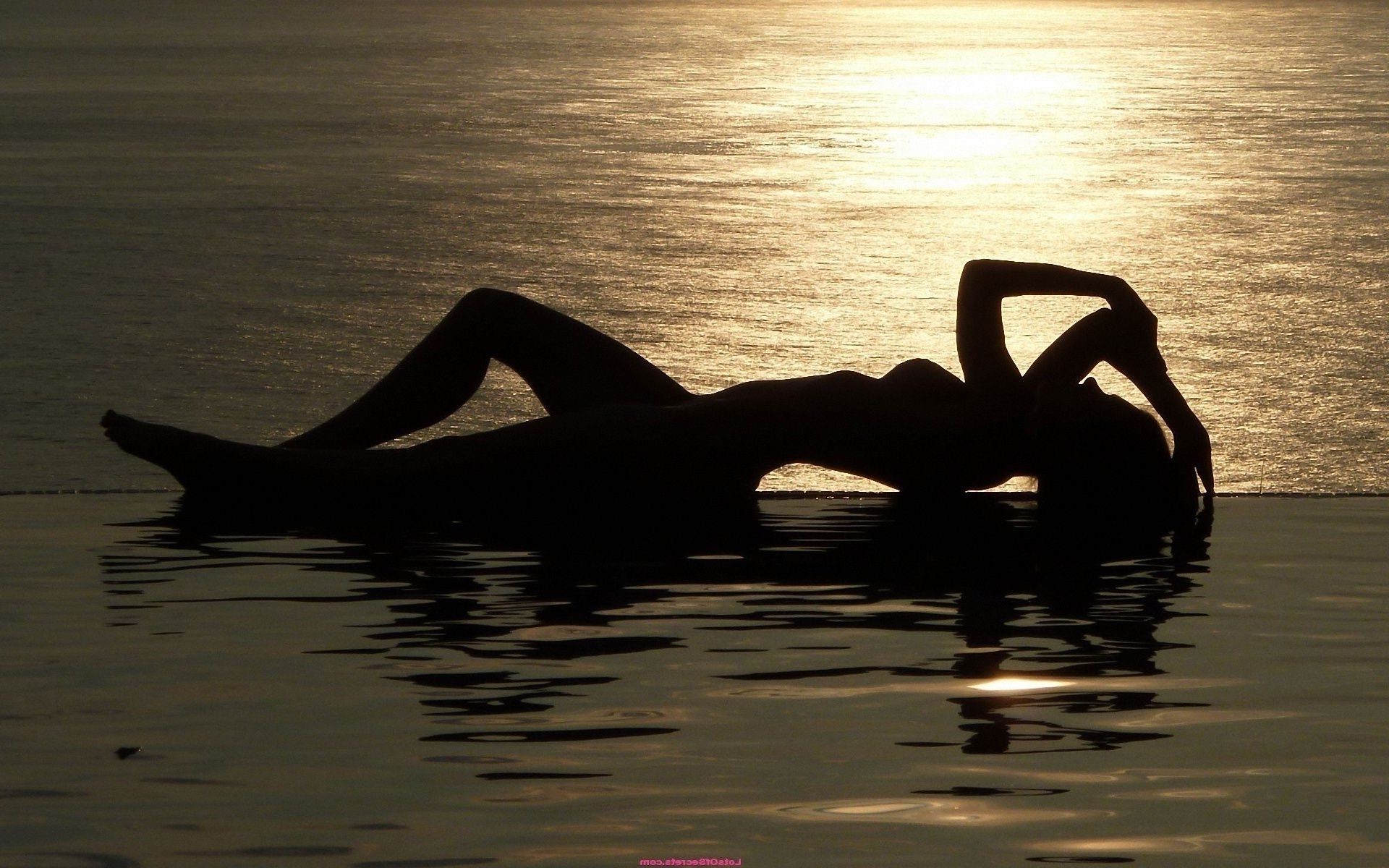 The sun glare water sea sunset Girl silhouette is - Phone 