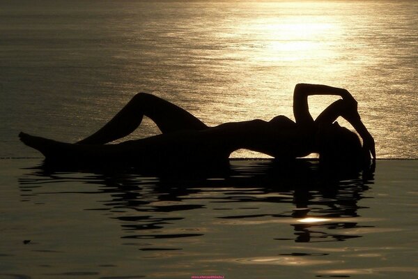 A girl in the water at sunset