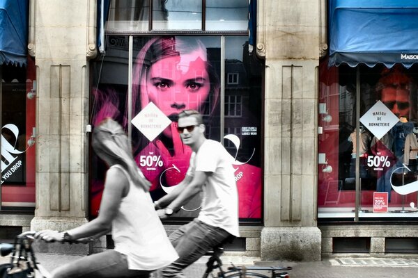 Deux sur des vélos sur fond de vitrine