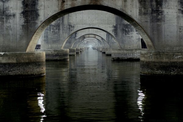 Reflection of the arches of the bridge in the water