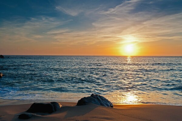 Soleil au coucher du soleil sur la surface de la mer