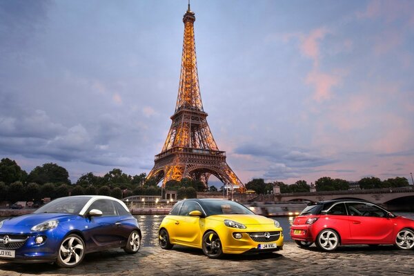 Colorful cars are parked on the square near the Eiffel Tower