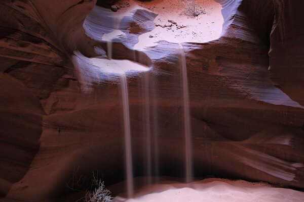 Le sable s effondre dans une grotte dans la roche