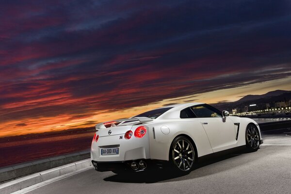 Voiture de sport sur fond de coucher de soleil