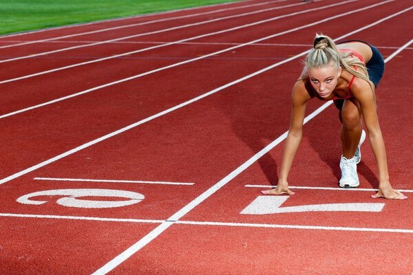 Das Mädchen bereitet sich auf den 100-Meter-Lauf vor