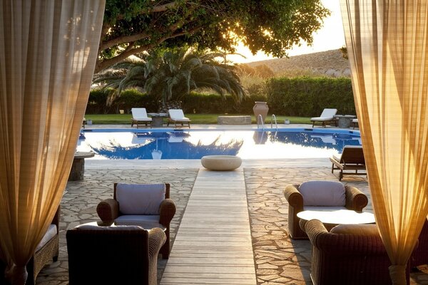 A hotel with a swimming pool and comfortable sun beds