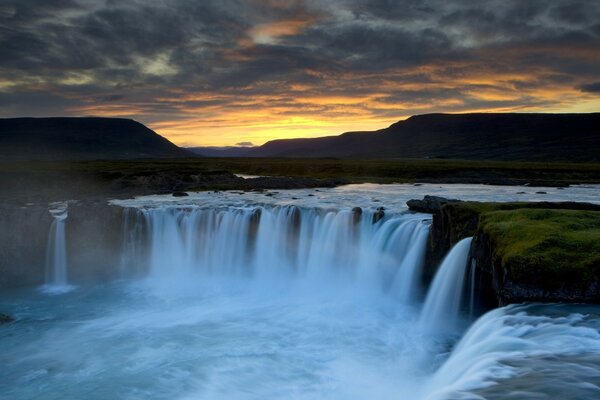 Beaucoup de cascades au coucher du soleil dans les montagnes