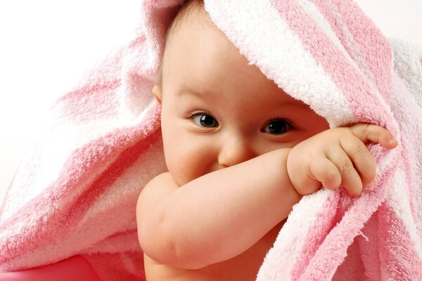 The baby hides in a towel