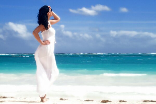 Fille modèle en blanc sur la plage en été