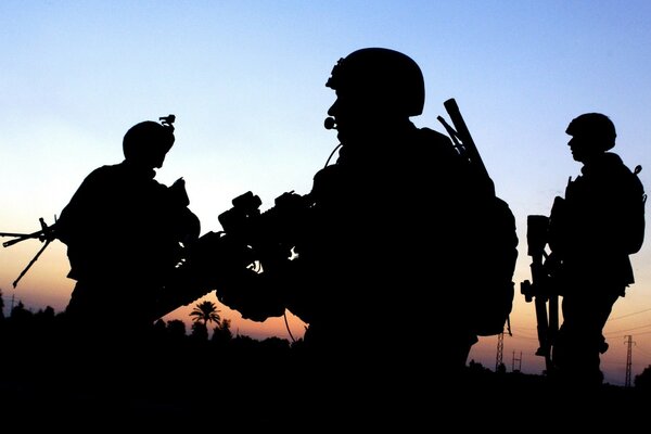 Silhouettes of special forces soldiers at sunset