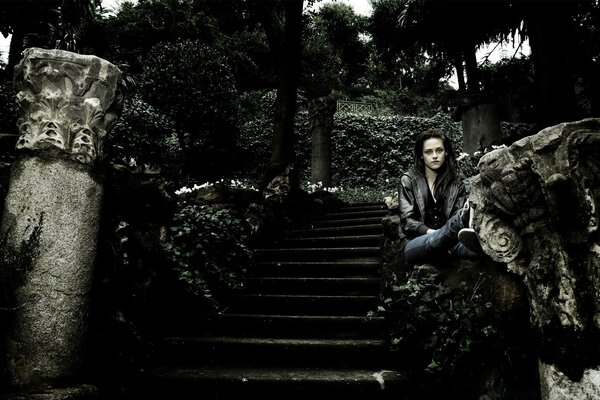 L actrice est assise sur un ancien escalier sombre