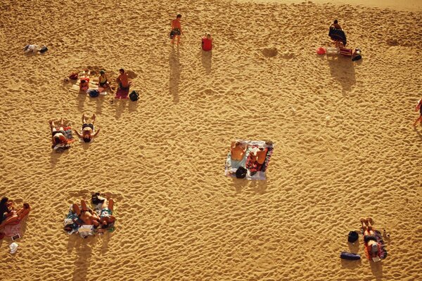 Pessoas descansando em uma praia arenosa