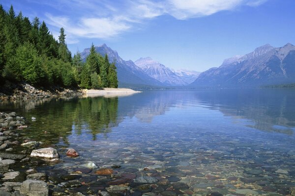 Lago transparente no fundo das montanhas nevadas