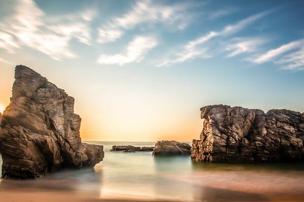 Dawn over calm water with rocks