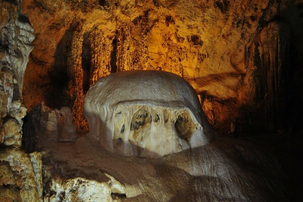 A cave illuminated by light from above with brown walls