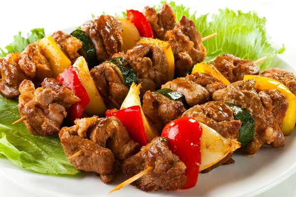 Juicy kebab on a plate with lettuce leaves