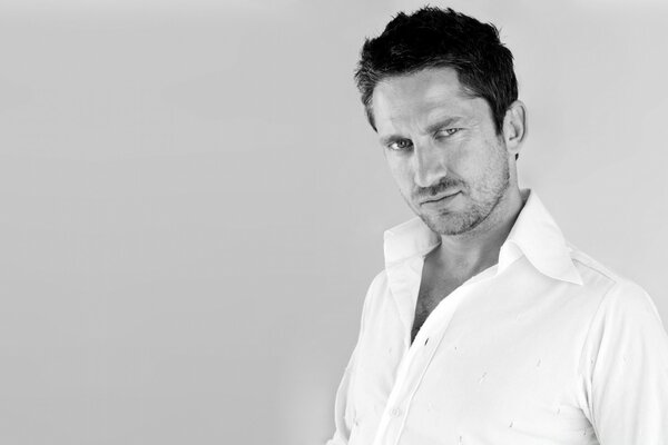 An adult actor poses in a white shirt