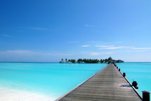 Eine lange Brücke vom Strand zum kleinen Skelett im Resort