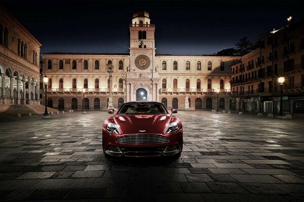 Elegante coche rojo cerca de un hermoso edificio