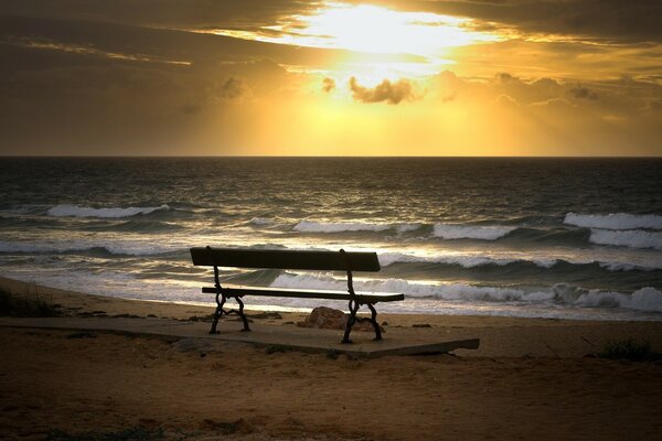 Eine Bank am Meer bei Sonnenuntergang