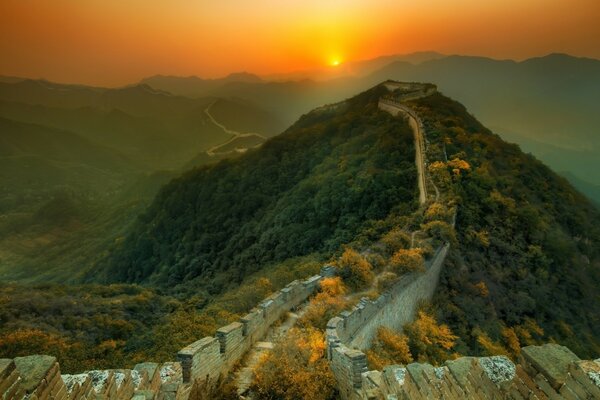 Uma colina com uma parede chinesa iluminada pelo amanhecer