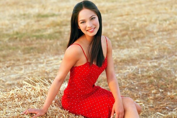 Black-haired beauty in a red dress on the field