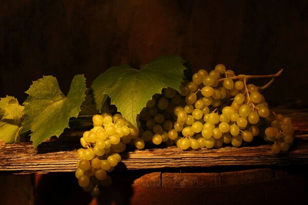 Bodegón de uva blanca tumbado en una pizarra